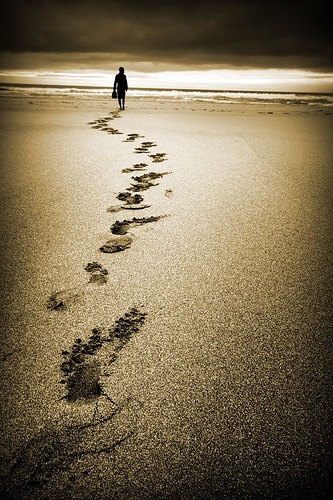 amber beach sceen footprints and person